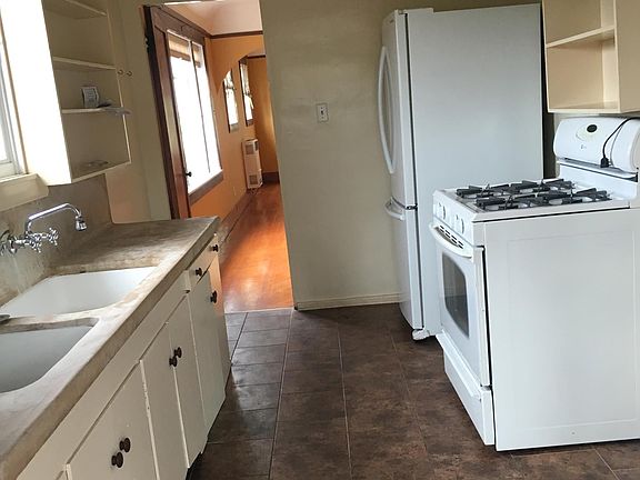 Kitchen includes refrigerator, gas stove, cast concrete counter tops. No garbage disposal or dishwasher.