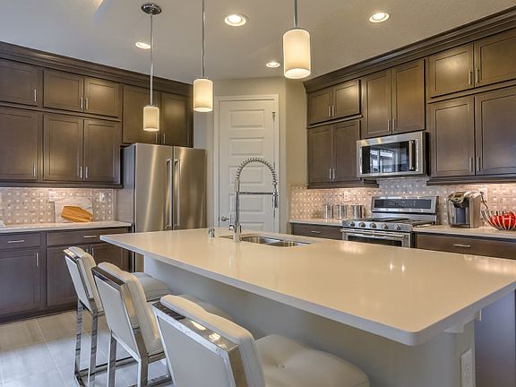 Kitchen offers plenty of cabinet space, a large pantry and many designer upgrades like quartz and st
