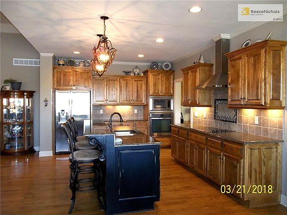 Kitchen showing Wood Floors, Custom Cabinets and Island with Bar.