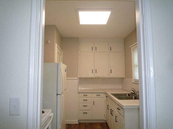 Kitchen with many cabinets, stove and refrigerator (no dishwasher)