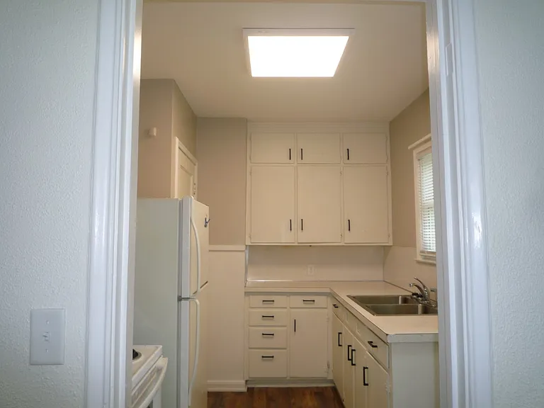 Kitchen with many cabinets, stove and refrigerator (no dishwasher)