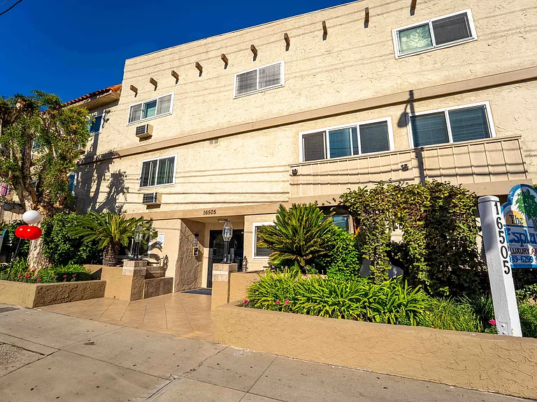 The entrance to The Esplanade features professional landscaping and a welcoming, well-maintained exterior.