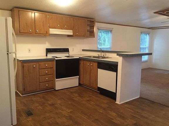Vinyl wood floors compliment this open kitchen which includes the refrigerator