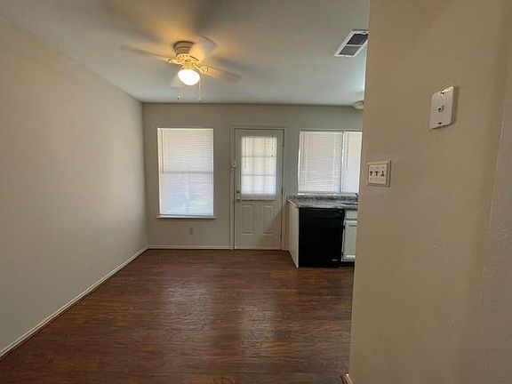 Doorway with dark wood-type flooring and ceiling fan