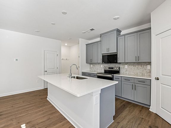 The large kitchen island can be used as a bar counter for additional seating.