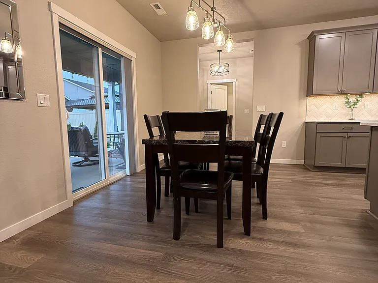 Dining area by sliding glass door. Sliding door opens to the covered patio with view of spacious back yard.