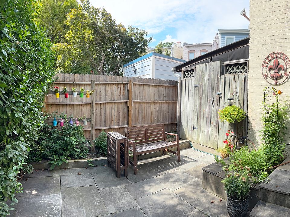 West view of private patio with gardens and shed.