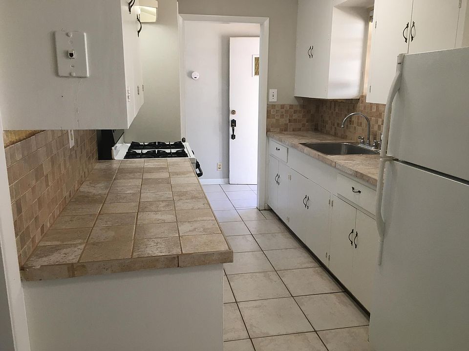 Kitchen with ceramic tile countertops, backsplash and floor.