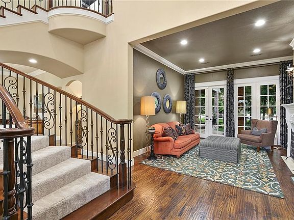 Luxurious finishes include handscraped hardwood flooring, intricate moldings, decorative lighting, wrought iron spindles & recently replaced carpet.