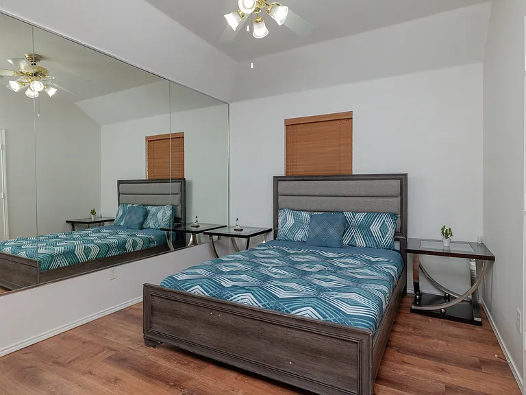 Bedroom #2 with queen size bed and mirrored wall.
