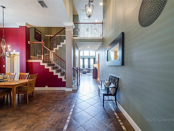 Classic David Weekley WOW factor diagonal tile two story entry with a mosaic border, wrought iron st
