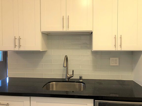 Remodeled kitchen with Shaker cabinets, quartz countertop, and European-style backsplash