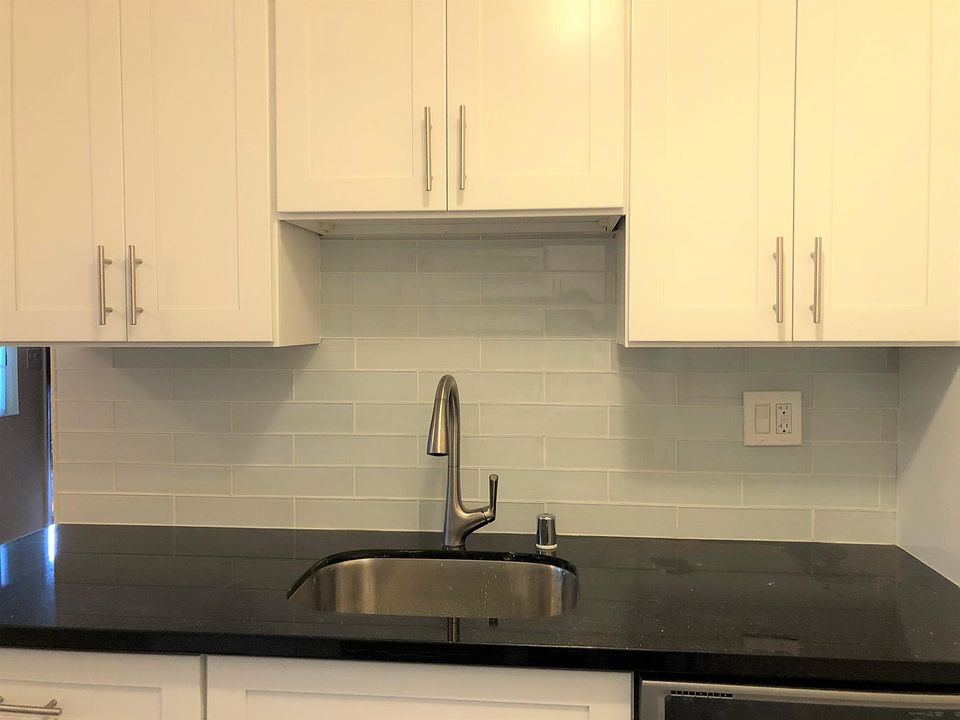 Remodeled kitchen with Shaker cabinets, quartz countertop, and European-style backsplash