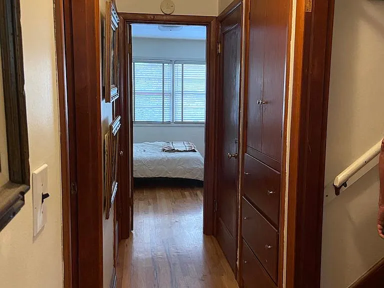 Hallway looking towards bedroom, stairway to upper floor on right