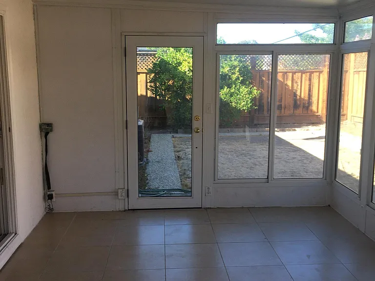 Glass sun room door leads to backyard and fragrant lemon tree