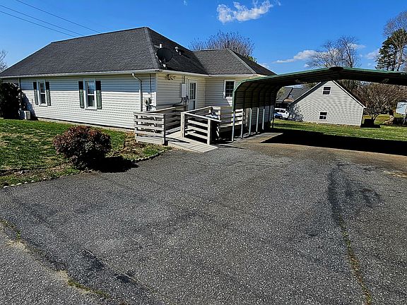 Rear entrance w/ handicap ramp and a covered & lit carport