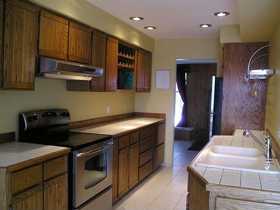 Kitchen with newer appliances & tiled counters