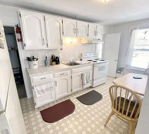 A galley style kitchen that fits a nice sized table and has tons of natural light!