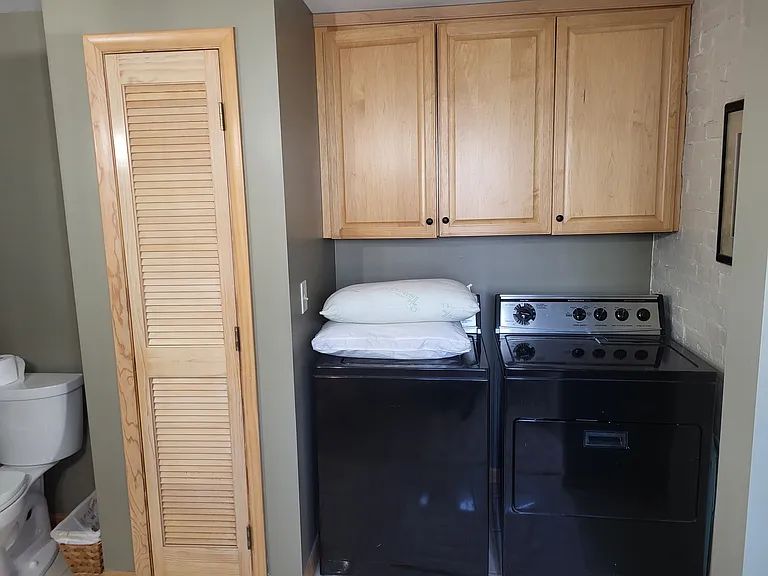Washer/dryer integrated with bathroom. Closet contains instant-on tankless water heater.