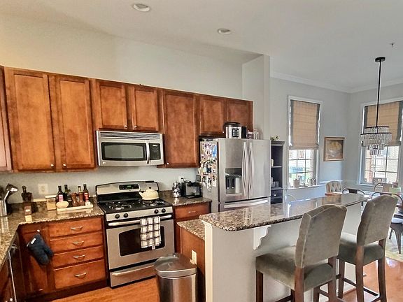 Kitchen featuring stainless steel appliances and two-tiered island with breakfast bar