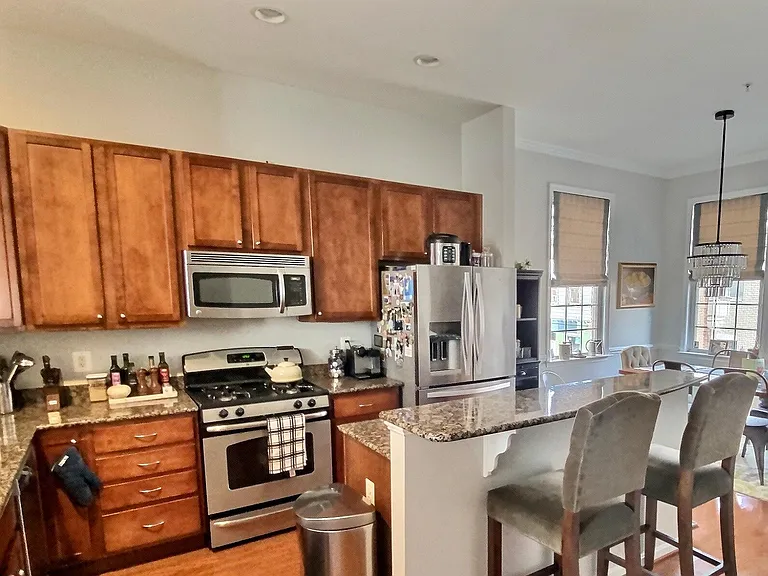 Kitchen featuring stainless steel appliances and two-tiered island with breakfast bar
