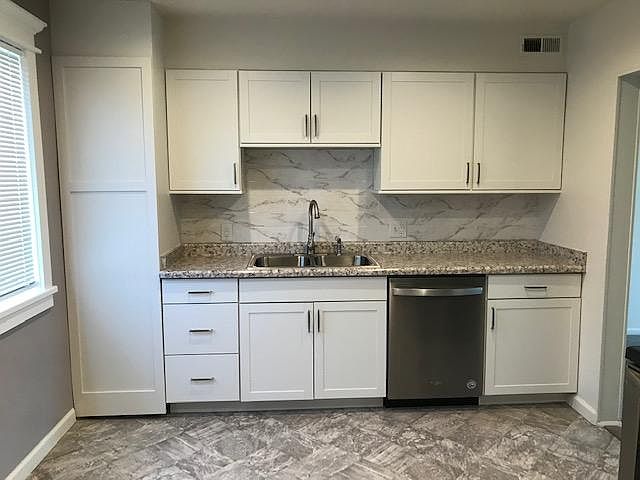Countertop are gorgeous & so is the tile backsplash on the wall behind the kitchen sink. All of the colors & textures in the kitchen are gorgeous & harmonize beautifully.