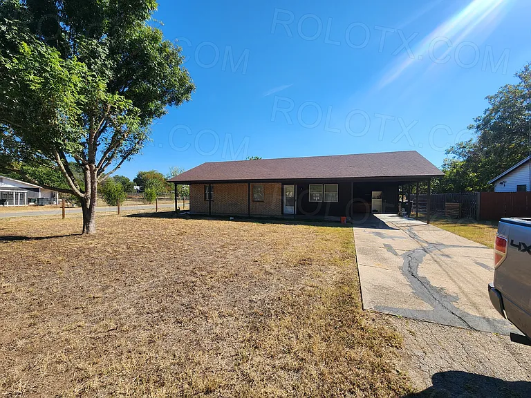 Front of home w/ wide covered porch and single car carport. Front, side and back door access.