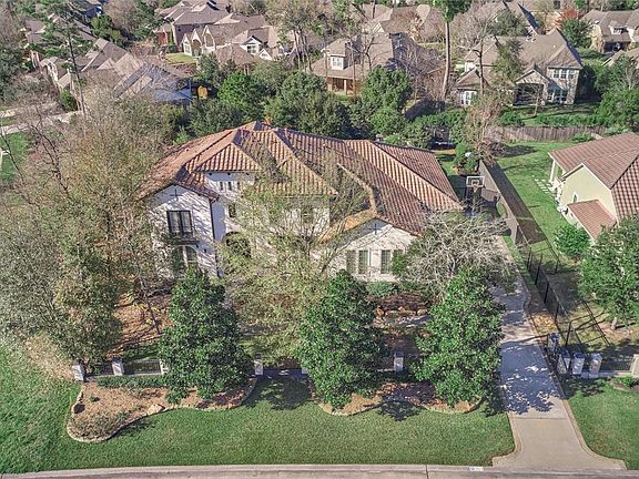 An elevated view of the property shows the privacy and mature landscaping surrounding the home! The home has a freshly painted exterior and gorgeous tile roof! There are no neighbors to the side or front of the home! The home has a private gated driv