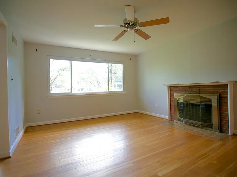 Spacious and well-lit living room with cozy fireplace