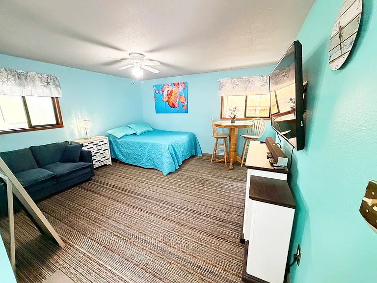 Photo from entryway door - queen bed with foam topper, loveseat, e-fireplace, 45" TV, mirror, pubtable