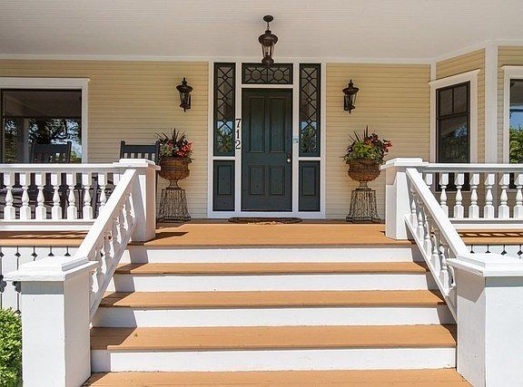 Welcoming front entrance leads to covered porch and custom front door.