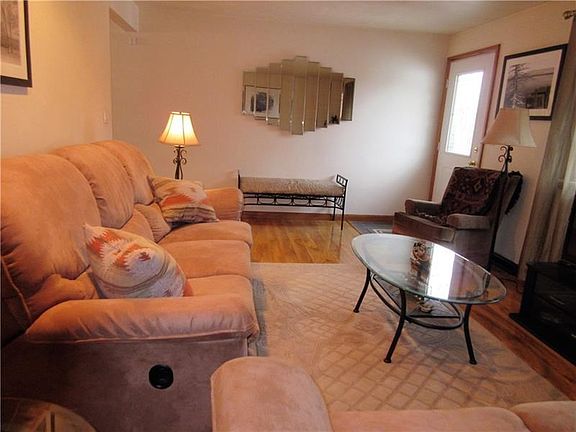 Recessed lighting above the couch, and ceramic tile entry coming in the front door.