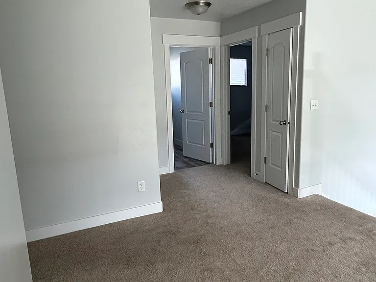 Hallway view of small closet, bedroom 1 and laundry room