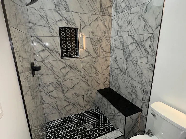 hexagon tile on the floor and niche of the bathroom w/ quartz seated bench