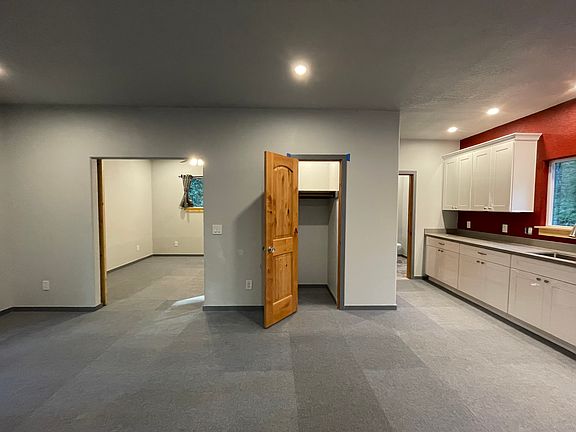 Entry closet in living room; open floor plan - living room and kitchen; barn door entry to bedroom