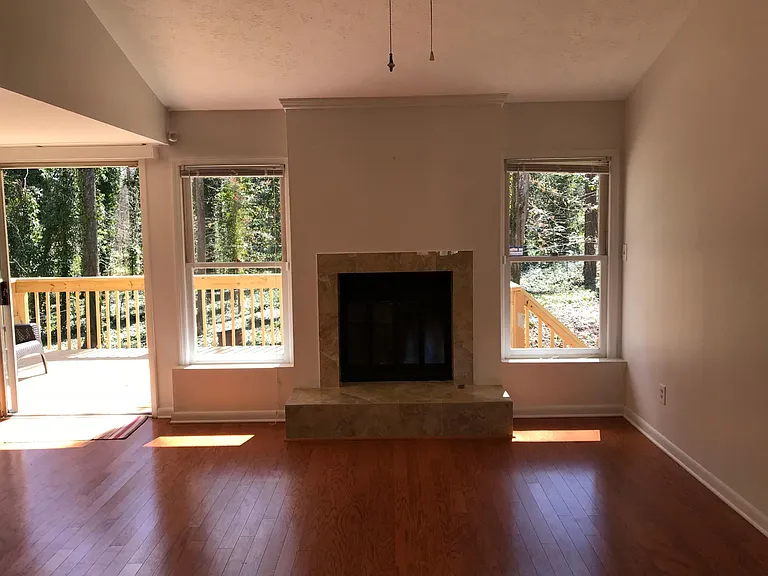 Fireplace in living room with a great view to the quiet and beautiful backyard, and a big backyard deck.