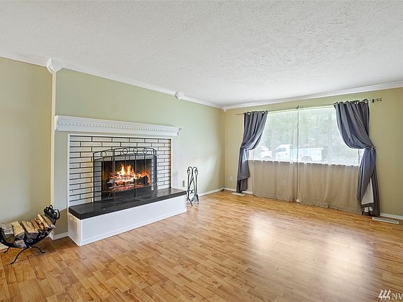 Fantastic living room with real wood burning fireplace, crown molding and laminate floors. 