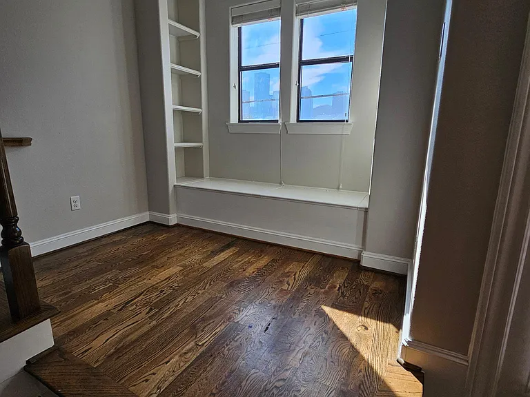 Reading nook with plenty of storage by stairs leading up to 3rd floor