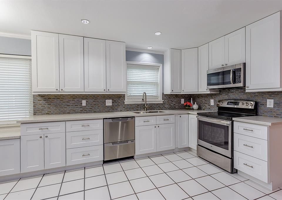 The kitchen was beautifully remodeled in 2016 with full height white soft close cabinets, Quartz counter tops, mosaic back-splash, 2 dishwashers, recessed lights, electric range, and built in microwave!