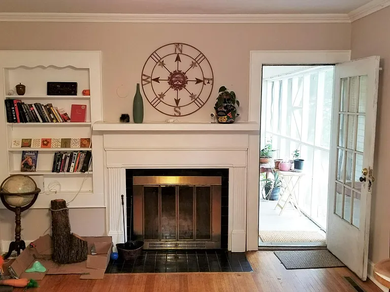 Living room with wood burning fireplace, and screened in porch