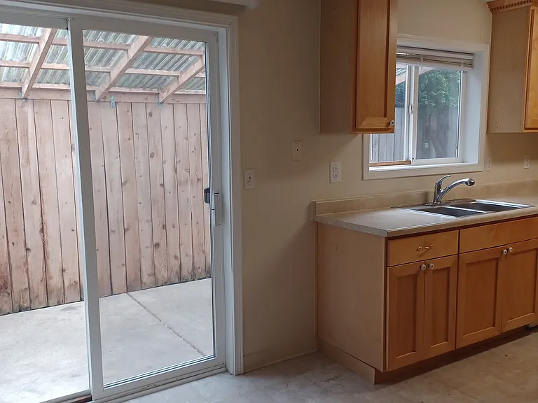 Sliding door to covered and fenced back patio area
