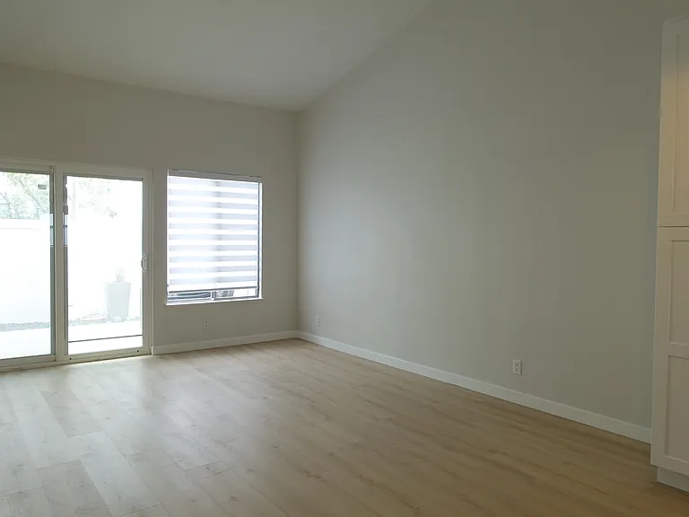 Living Room: Sliding doors to patio. Large window with cordless cloth blind and filtered light.