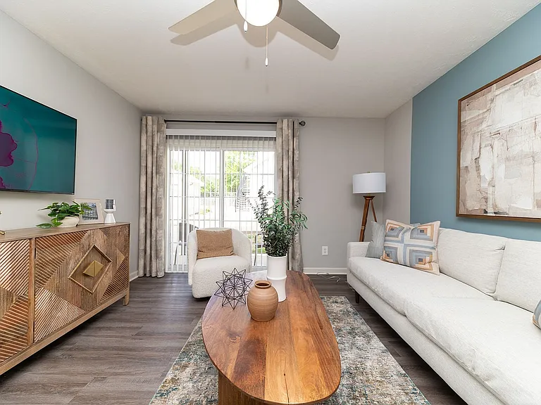 Spacious living room with hardwood-style flooring & ceiling fan