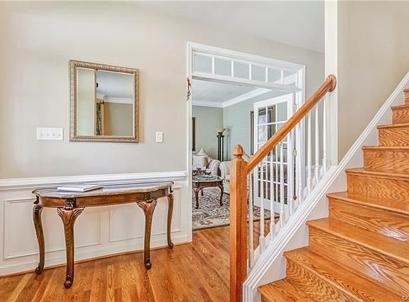 Foyer with hardwood floors and hardwood on stairs - beautiful wood moldings.  French doors leading to formal living room