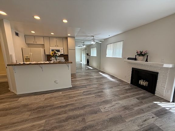 View of dining area off kitchen next to faux fireplace.