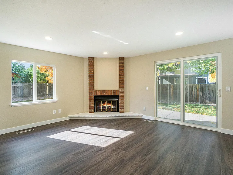 Family room with wood burning fireplace, slider to patio and fenced yard