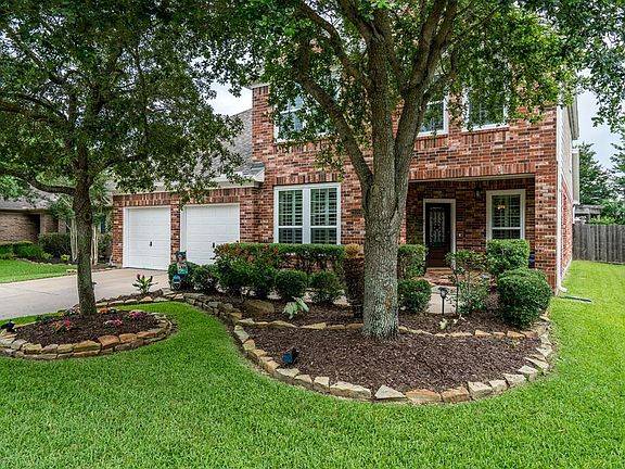 Mature trees and lush landscaping surrounded by flagstone borders offers great curb appeal!