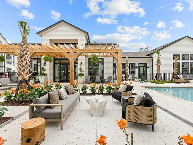 Luxury apartment pool with outdoor lounge seating, shaded pergola, and resort-style amenities designed for relaxation and socializing.