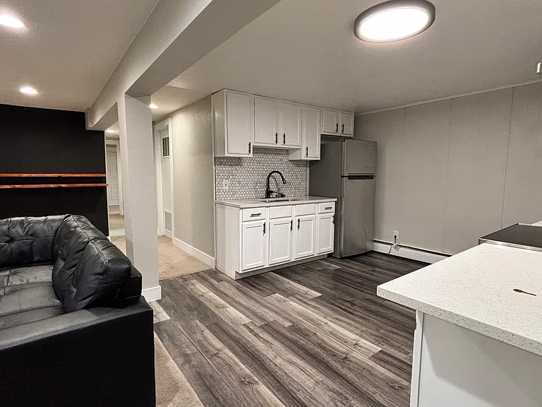Open kitchen area with modern appliances, flowing nicely from living area