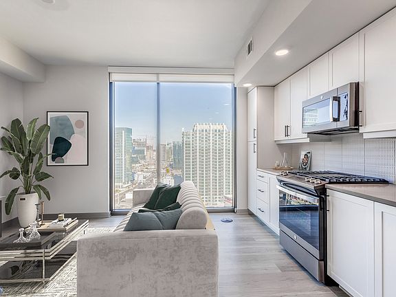 Studio Living Area and Kitchen with Floor to Ceiling Windows and Views of the City